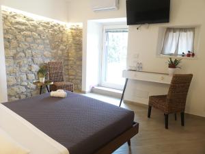 a bedroom with a bed and a stone wall at Panorama Suite in Piazza Armerina