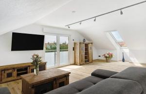 a living room with a couch and a flat screen tv at Moderne offene Dachgeschoßwohnung in Linx