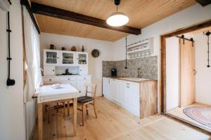 a kitchen with white cabinets and a table and chairs at Sielsko in Lipsko-Polesie +28 photos
