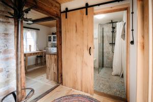 a bathroom with a shower and a wooden door at Sielsko in Lipsko-Polesie