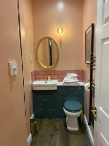 a bathroom with a toilet and a sink and a mirror at The Nest at Corbies Rest in Inverness