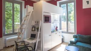 a room with a white refrigerator and a desk with a laptop at BonAppart 2 - Charme Napoléonien & Confort in Troyes