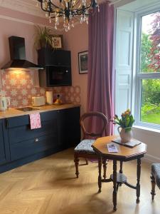 a kitchen with a table and a chair and a table at The Nest at Corbies Rest in Inverness +4 photos