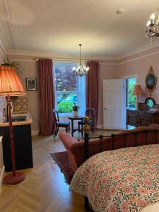 a bedroom with a bed and a table and a window at The Nest at Corbies Rest in Inverness