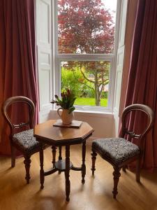 a table and two chairs and a window at The Nest at Corbies Rest in Inverness