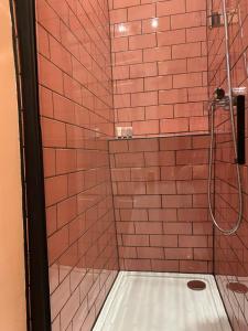 a bathroom with a shower with red tile walls at The Nest at Corbies Rest in Inverness