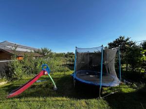 a trampoline and a swing set in the grass at Casuta din livada in Turda