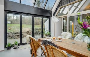 a dining room with a wooden table and windows at 4 Bedroom Stunning Home In Knebel in Knebel