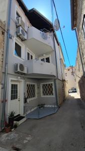 a white building with a door and a balcony at Apartments Marin in Tisno
