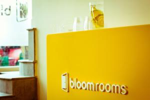 a yellow wall with the word bloomrooms on it at Bloomrooms @ New Delhi Railway Station in New Delhi