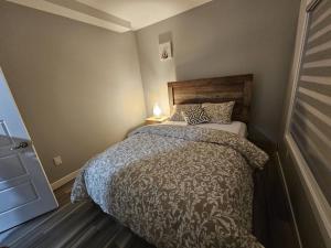 1 dormitorio con 1 cama con edredón en Cozy 2bed Guest suite, en Calgary