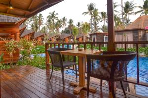 una terrazza con tavolo e sedie accanto alla piscina di Gili Air Lagoon Resort By Waringin Hospitality a Gili Air Altre 32 foto