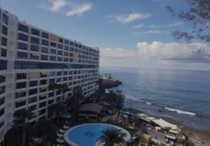 a view of a hotel and the ocean from a balcony at Beachfront Patalavaca in Patalavaca