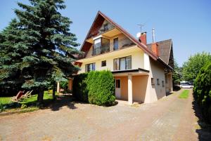 a house with a tree and a brick driveway at Adonis in Chłopy
