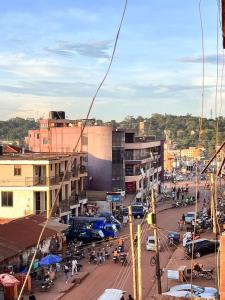 Une rue animée avec des voitures et des gens dans une ville dans l'établissement Magical suite, à Kampala