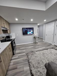 Una cocina con un televisor en la pared y un suelo. en Cozy 2bed Guest suite, en Calgary 7 fotos más