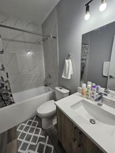 y baño con lavabo, aseo y bañera. en Cozy 2bed Guest suite, en Calgary
