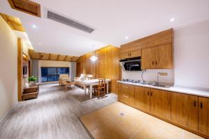 a kitchen with wooden cabinets and a dining room at Hongfu Villa - Zhangjiajie National Forest Park West Gate in Zhangjiajie