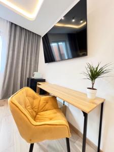 a table and a yellow chair in a room at Milan Boutique Villa in Paderno Dugnano