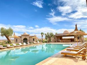 a resort pool with lounge chairs and a gazebo at Luxury Villa Rêve D'ahlam à MARRAKECH in Oulad Boudene