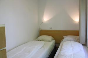 two beds in a small room with white walls at Previnaireweg 19 in Callantsoog