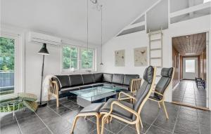 ein Wohnzimmer mit einem schwarzen Sofa und Stühlen in der Unterkunft Holiday Home Jtagholmsvej Rømø Denmark in Rømø Kirkeby