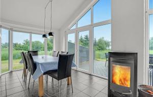 ein Esszimmer mit Tisch und Kamin in der Unterkunft Holiday Home Jtagholmsvej Rømø Denmark in Rømø Kirkeby