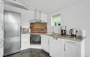 eine Küche mit weißen Schränken und Geräten aus Edelstahl in der Unterkunft Holiday Home Jtagholmsvej Rømø Denmark in Rømø Kirkeby + 22 Fotos