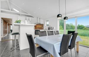 eine Küche und ein Esszimmer mit Tisch und Stühlen in der Unterkunft Holiday Home Jtagholmsvej Rømø Denmark in Rømø Kirkeby