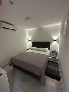 a bedroom with a large bed in a white room at Apartmani Žaneta in Kaštela