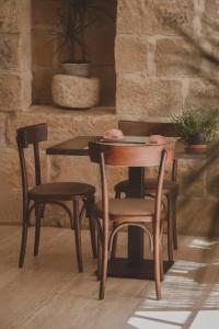 a wooden table with two chairs and a table with at Maria Rosa Suites in Victoria