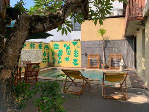 a patio with chairs and a table and a pool at Cozy Palm Villa in Jimbaran