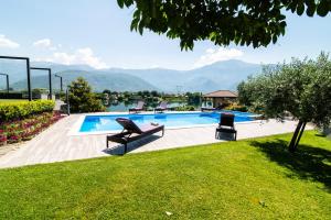 a swimming pool with two chairs in a yard at Villa Ana in Mostar
