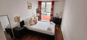 a small bedroom with a bed and a window at Excel West Stays in London