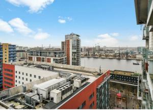 a view of a city with a river and buildings at Excel West Stays in London