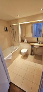 a bathroom with a shower and a toilet and a sink at Excel West Stays in London