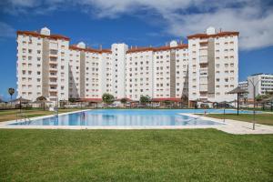 Un gran edificio de apartamentos con una gran piscina. en Brisa marina, en El Puerto de Santa María