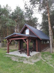 a picnic shelter with a picnic table in a park at Dom Nad Stawem Krawno in Piecki