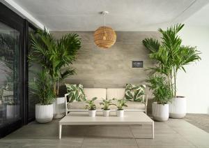 a living room with a couch and potted plants at Waterstone Resort & Marina Boca Raton, Curio Collection by Hilton in Boca Raton