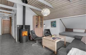 a living room with a couch and a fireplace at Cozy Home In Hadsund With Sauna in Helberskov