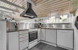 a kitchen with white cabinets and a black ceiling at Cozy Home In Hadsund With Sauna in Helberskov