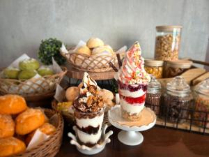 札幌市にあるホテルリリーフ札幌すすきのの3つのデザートとパンのバスケットが置かれたテーブル