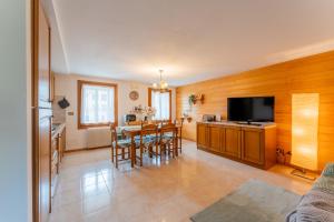 a kitchen and dining room with a table and a television at Grande Terrazzo - Zona Silenziosa e Strategica in Roana +41 photos