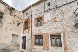 ein Steingebäude mit Fenstern und einem Schild darauf in der Unterkunft El Rincon De La Morena in Montemayor de Pililla