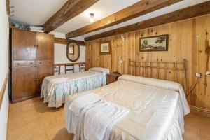 zwei Betten in einem Zimmer mit Holzwänden in der Unterkunft El Rincon De La Morena in Montemayor de Pililla