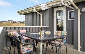 una mesa con sillas y una botella de vino en la terraza en Cozy Home In Harboøre With Sauna, en Harboør 26 fotos más