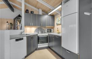 Una cocina con gabinetes grises y un refrigerador. en Cozy Home In Harboøre With Sauna, en Harboør
