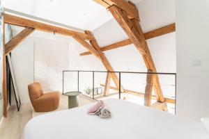 - une chambre avec deux lits blancs et une chaise dans l'établissement L'élégant - Appartement Fonctionnel Plein-centre de Douai, à Douai 11 autres photos