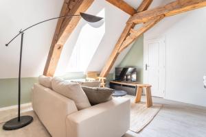 - un salon avec un canapé blanc et une lampe de chevet dans l'établissement L'élégant - Appartement Fonctionnel Plein-centre de Douai, à Douai