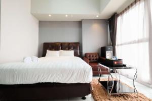 a bedroom with a large bed and a chair at Exclusive Studio Casa de Parco Apartment By Travelio in Jati +14 photos